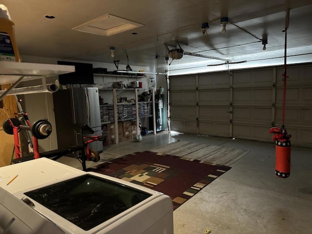 garage with washer / clothes dryer and stainless steel refrigerator