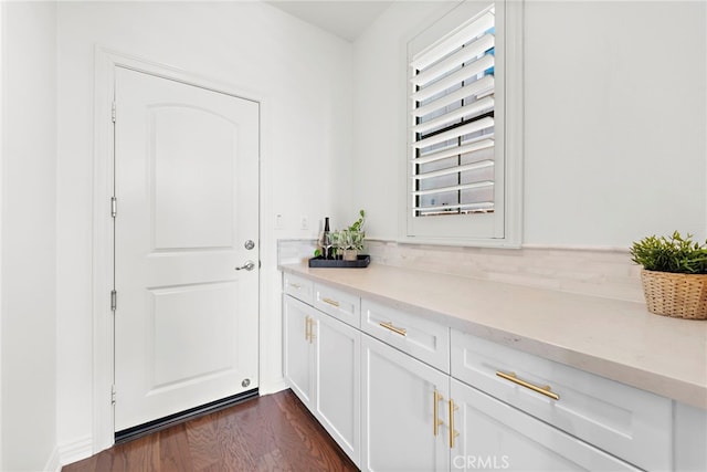 bar featuring white cabinetry and dark wood-type flooring