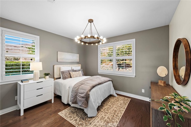 bedroom featuring multiple windows, dark hardwood / wood-style flooring, and a notable chandelier