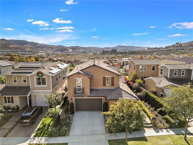 view of front of house with a mountain view, solar panels, and a garage