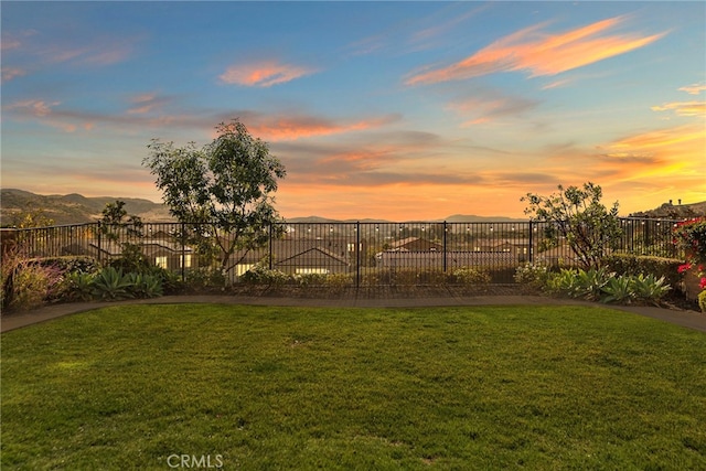 yard at dusk featuring a mountain view