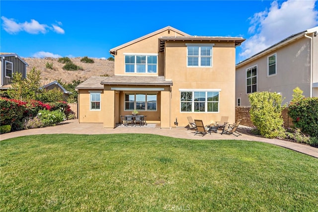 rear view of house featuring a yard and a patio