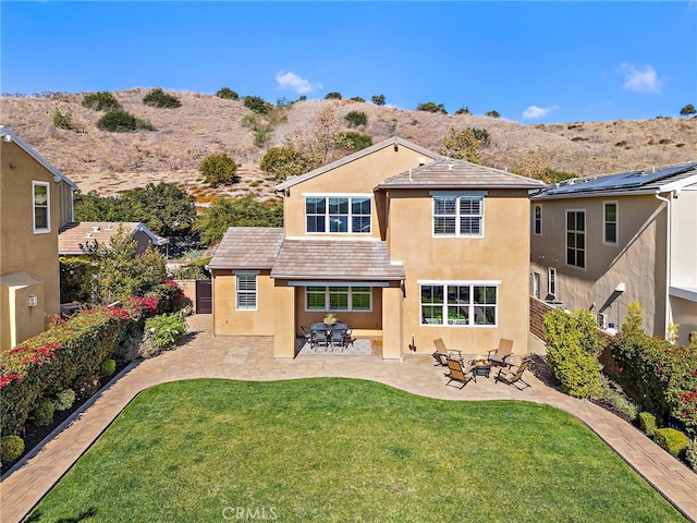 rear view of property featuring a patio area and a yard