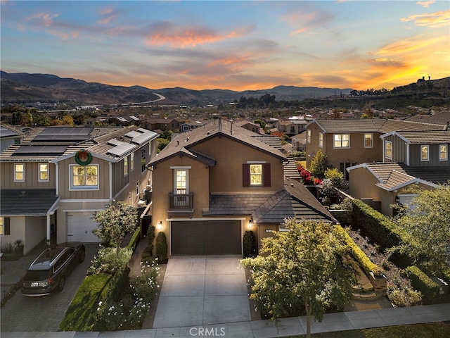 view of front of home with a mountain view, a garage, and solar panels