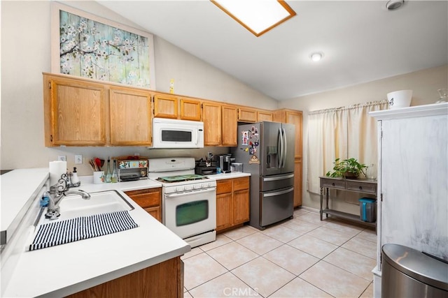 kitchen with lofted ceiling, sink, light tile patterned floors, and white appliances