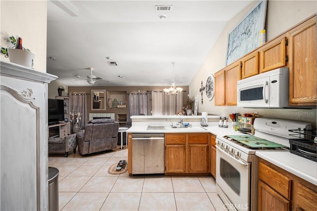 kitchen featuring white appliances, ceiling fan with notable chandelier, hanging light fixtures, light tile patterned floors, and kitchen peninsula