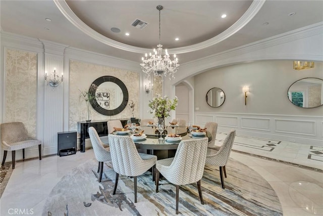 dining room featuring a tray ceiling, a chandelier, and ornamental molding