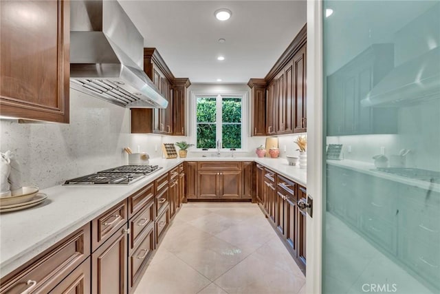 kitchen with decorative backsplash, cooktop, ventilation hood, stainless steel gas cooktop, and wall chimney range hood