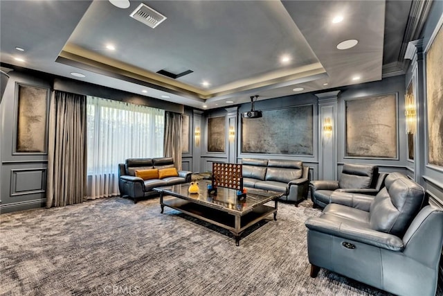 carpeted home theater with a tray ceiling