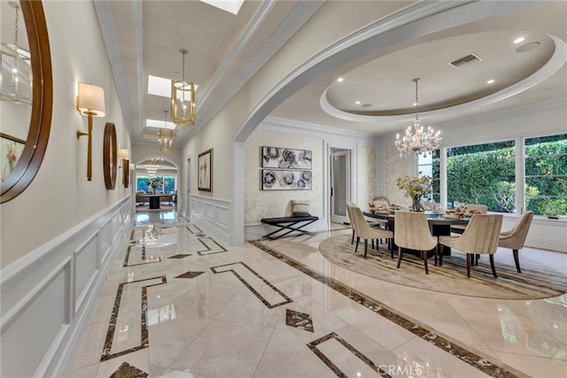 interior space featuring an inviting chandelier, crown molding, and a tray ceiling