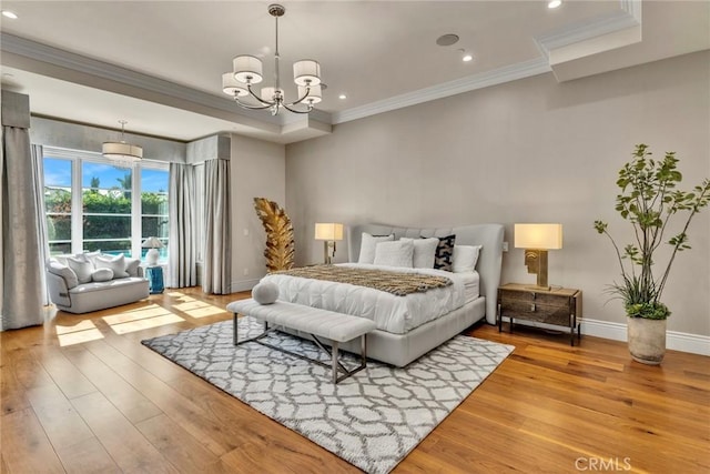 bedroom with light hardwood / wood-style floors, an inviting chandelier, and ornamental molding