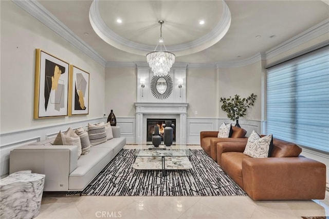 living room with a chandelier, ornamental molding, and a tray ceiling