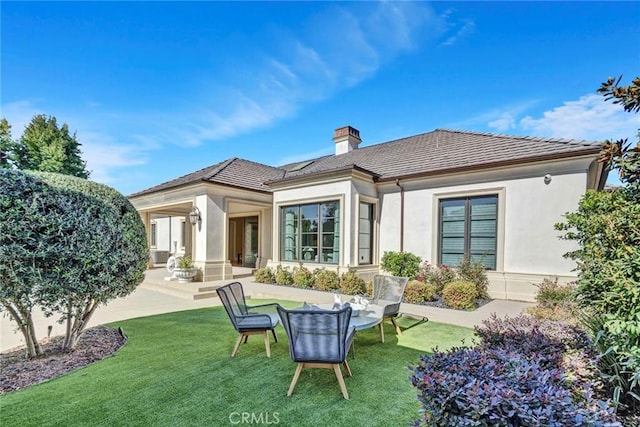 back of house featuring a yard and a patio