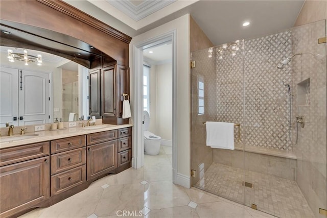 bathroom with toilet, vanity, an enclosed shower, and ornamental molding