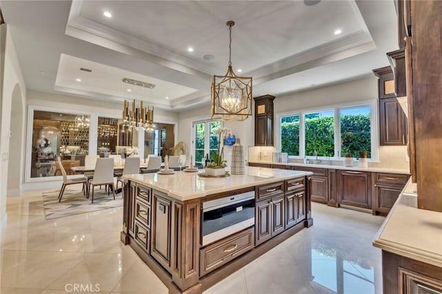 kitchen featuring a center island, hanging light fixtures, and a tray ceiling