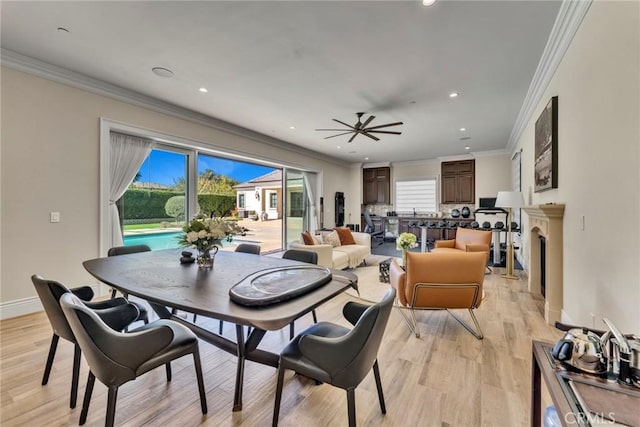 dining area featuring light wood-type flooring, ceiling fan, and ornamental molding