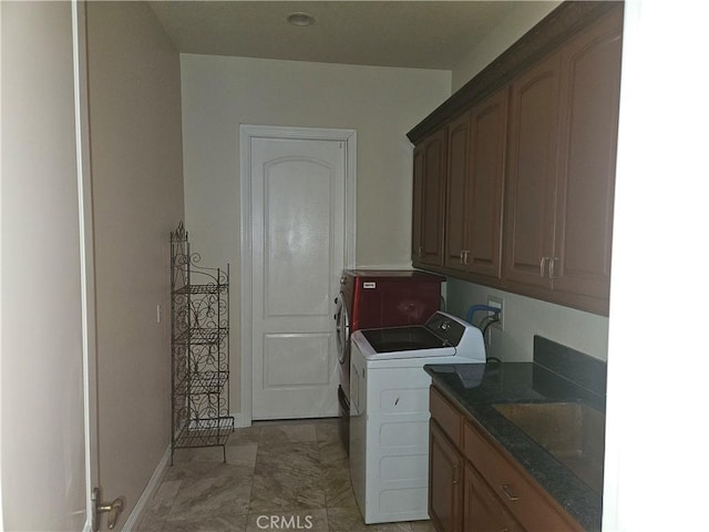 clothes washing area with cabinets, independent washer and dryer, and sink