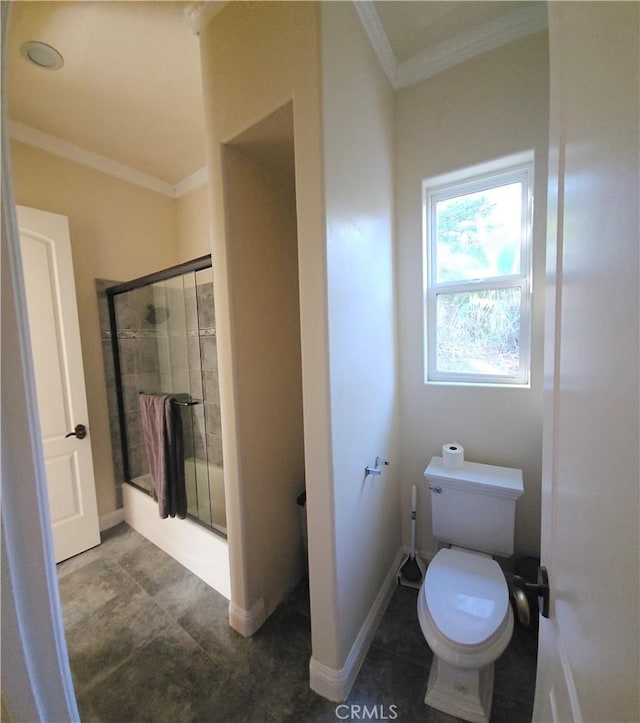 bathroom with tile patterned floors, crown molding, toilet, and bath / shower combo with glass door