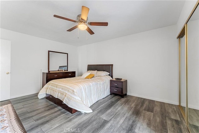 bedroom with ceiling fan, a closet, and dark hardwood / wood-style floors