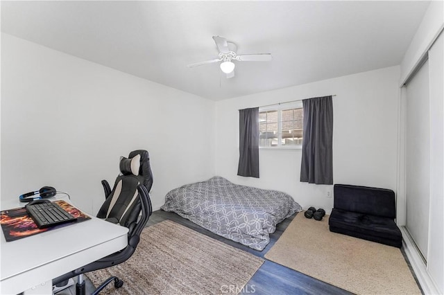 bedroom with wood-type flooring, a closet, and ceiling fan