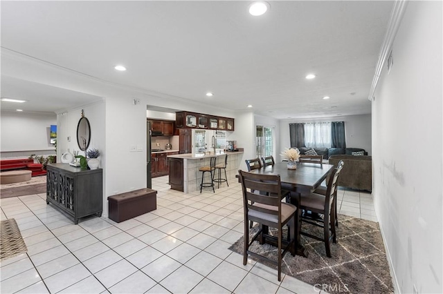 dining room with ornamental molding and light tile patterned floors