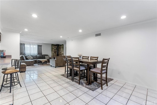 tiled dining room featuring ornamental molding