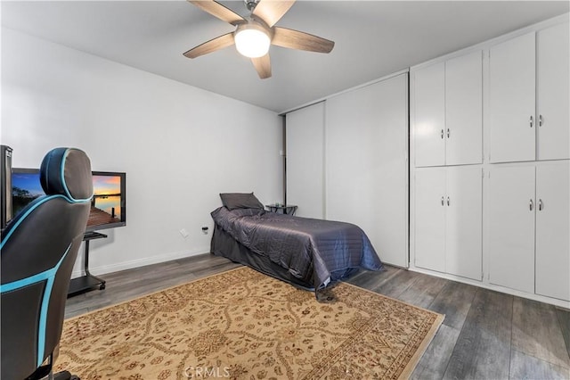 bedroom with ceiling fan and dark wood-type flooring