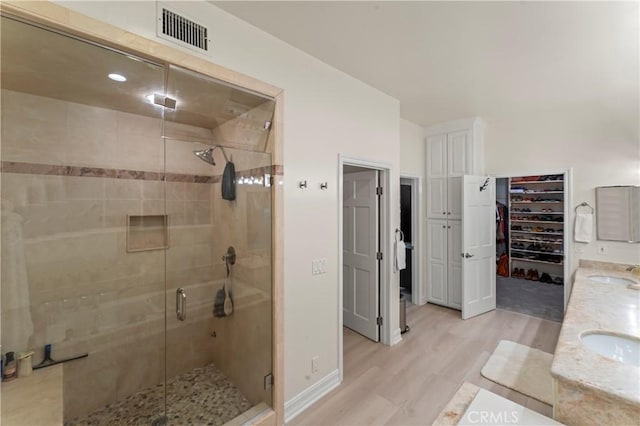 bathroom with vanity, a shower with shower door, and hardwood / wood-style floors