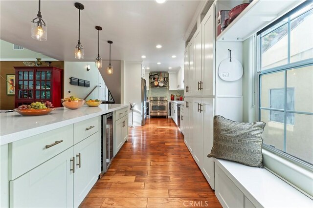 2355 N Beverly Glen Blvd, Los Angeles, CA 90077 - kitchen with appliances with stainless steel finishes, wine cooler, light wood-style floors, hanging light fixtures, and white cabinets