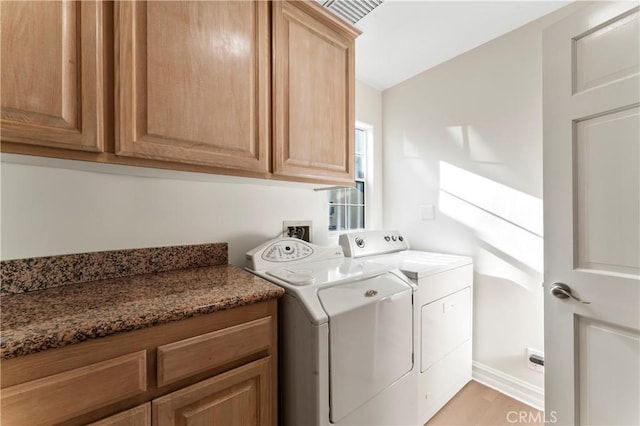 washroom with cabinets, independent washer and dryer, and light wood-type flooring