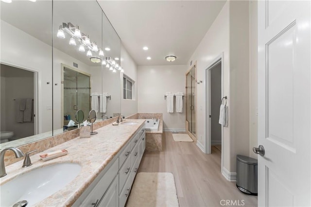 bathroom featuring wood-type flooring, independent shower and bath, and vanity