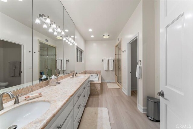 2355 N Beverly Glen Blvd, Los Angeles, CA 90077 - full bath featuring wood finished floors, a garden tub, double vanity, a stall shower, and toilet