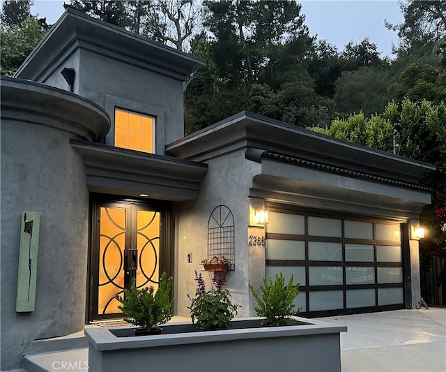 2355 N Beverly Glen Blvd, Los Angeles, CA 90077 - view of exterior entry featuring driveway, stucco siding, and a garage
