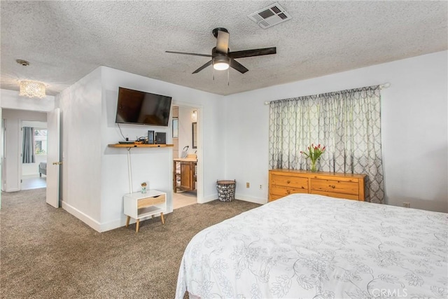 carpeted bedroom featuring ceiling fan, connected bathroom, and a textured ceiling