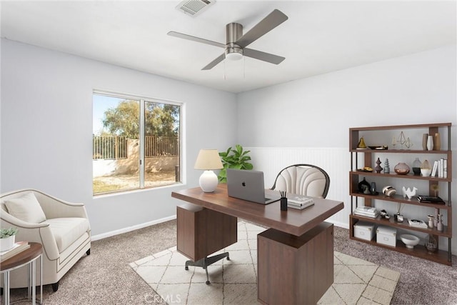 carpeted home office featuring ceiling fan