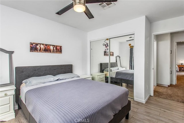 bedroom featuring ceiling fan, a closet, and light hardwood / wood-style flooring