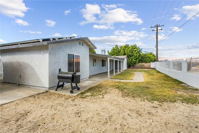 back of property featuring a yard and a patio