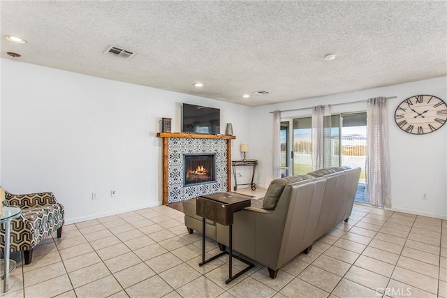 tiled living room with a textured ceiling and a fireplace