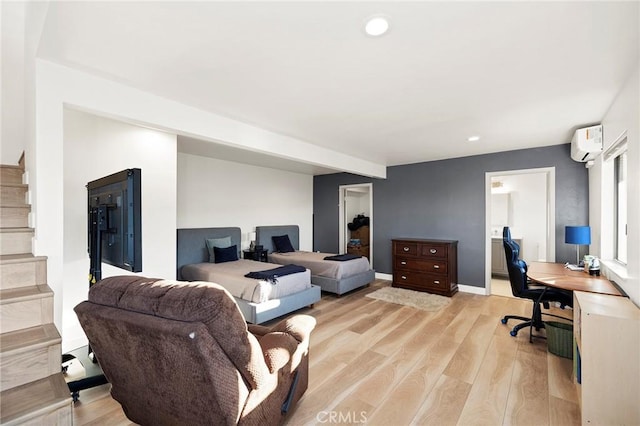 living room featuring an AC wall unit and light hardwood / wood-style floors