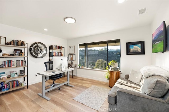 home office with light hardwood / wood-style flooring