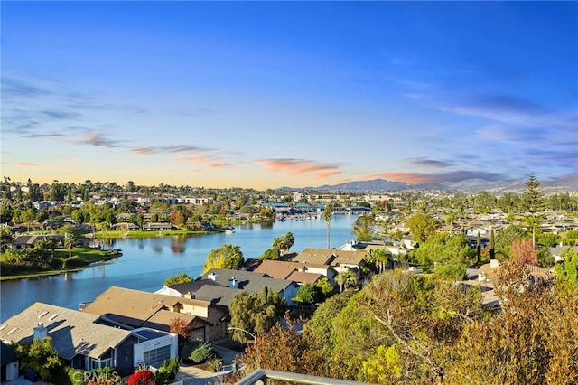 aerial view at dusk featuring a water view