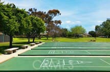 view of home's community with a lawn and shuffleboard