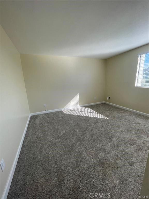 unfurnished room featuring dark colored carpet