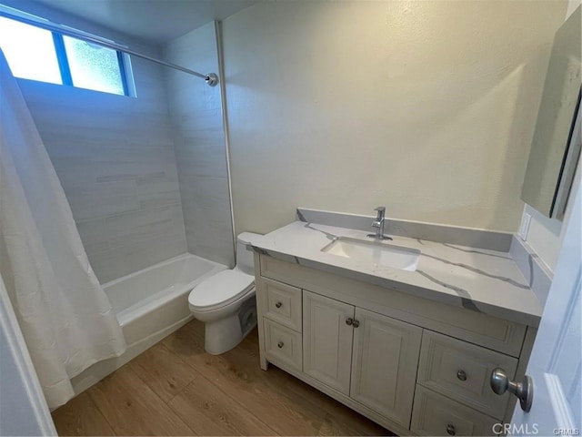 full bathroom with shower / tub combo, vanity, hardwood / wood-style flooring, and toilet