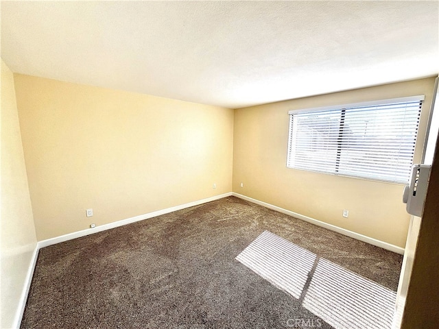 unfurnished room featuring carpet flooring and baseboards