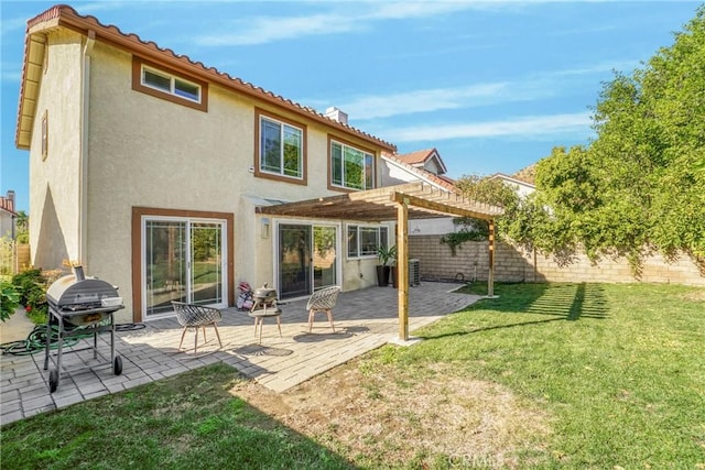 back of property with a pergola, a patio area, and a lawn