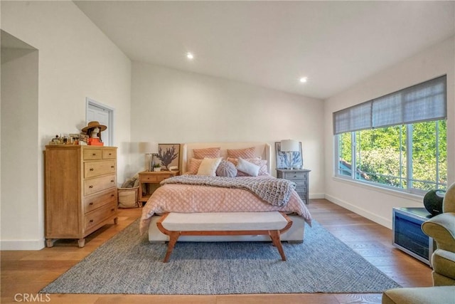 bedroom with wood-type flooring and vaulted ceiling