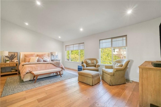 bedroom featuring light wood-type flooring and vaulted ceiling