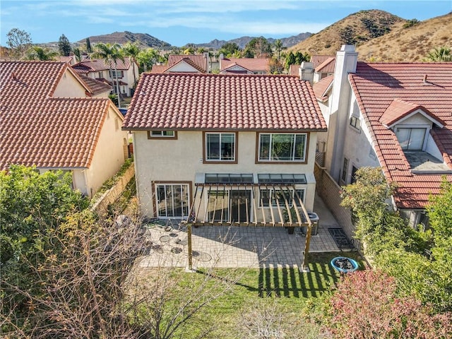 back of property featuring a mountain view and a patio