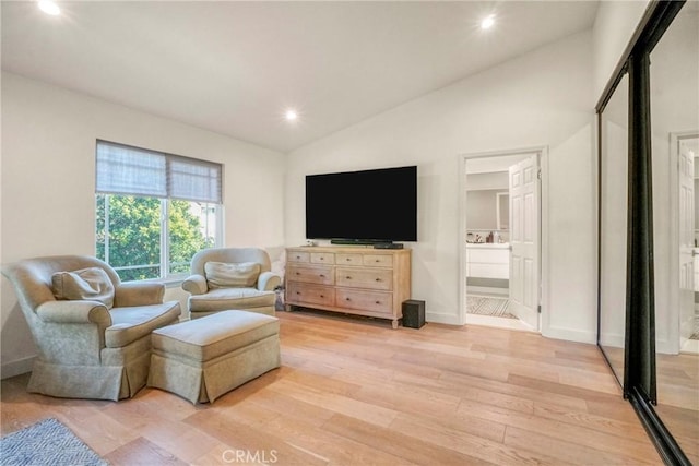 sitting room featuring lofted ceiling and light wood-type flooring